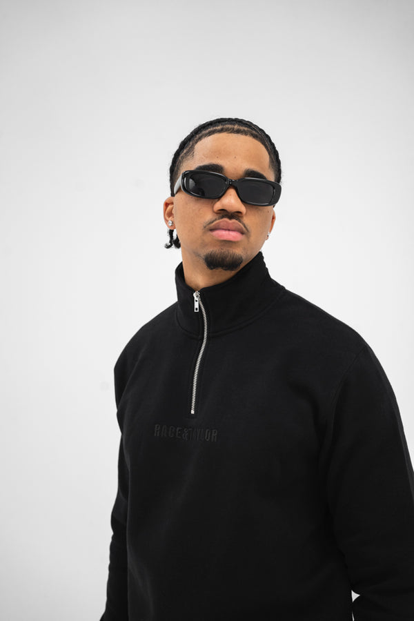 Black quarter zip sweatshirt with the Race & Taylor brand embroidery on the front.